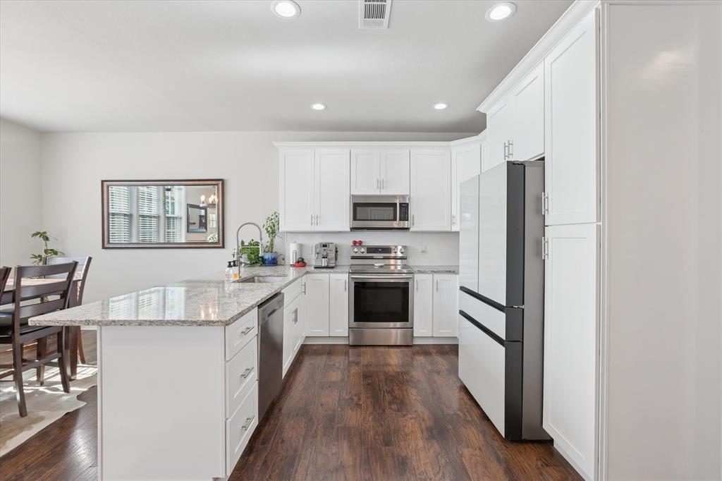 7232 Courtney Drive Azle, TX 76020 - Photo 13 of 39 a kitchen with stainless steel appliances granite countertop a refrigerator a stove top oven a sink dishwasher and white cabinets with wooden floor