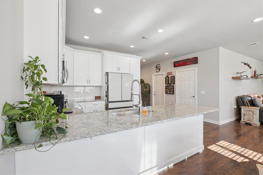 7232 Courtney Drive Azle, TX 76020 - Photo 14 of 39 a kitchen with stainless steel appliances kitchen island granite countertop a refrigerator and a sink