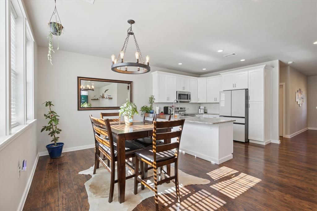 7232 Courtney Drive Azle, TX 76020 - Photo 18 of 39 a dining room with wooden floor a chandelier a wooden table and chairs
