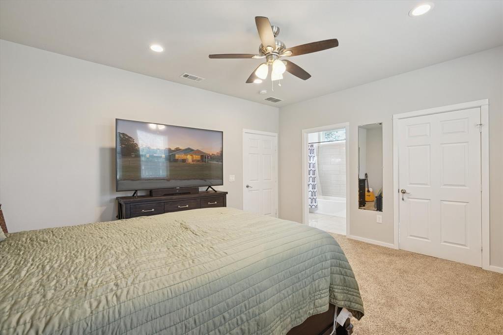 7232 Courtney Drive Azle, TX 76020 - Photo 24 of 39 a bedroom with a large bed and a flat tv screen
