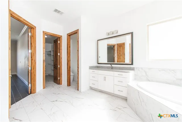 a bathroom with a bathtub sink and mirror