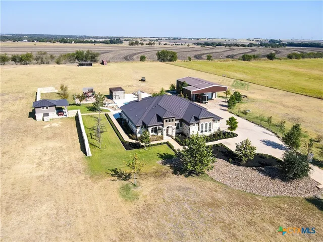 an aerial view of residential houses with outdoor space and ocean view