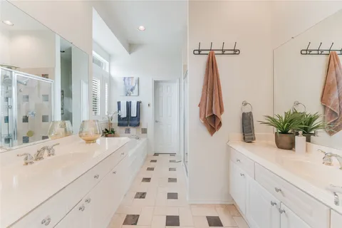 a bathroom with a double vanity sink a mirror a shower and a bathtub