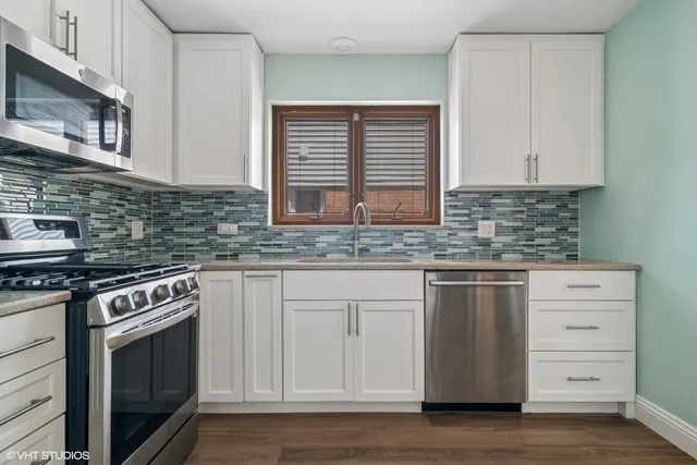 a kitchen with granite countertop white cabinets stainless steel appliances and a sink