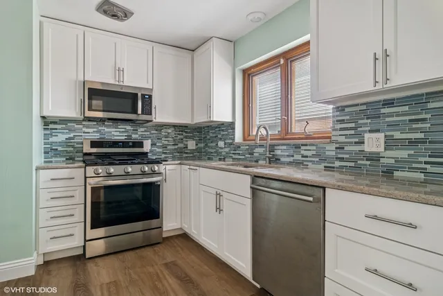 a kitchen with stainless steel appliances granite countertop a stove microwave and cabinets