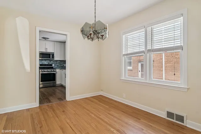 a view of a livingroom with wooden floor kitchen view and a window