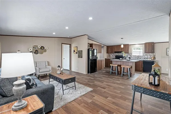 a living room with furniture and kitchen view
