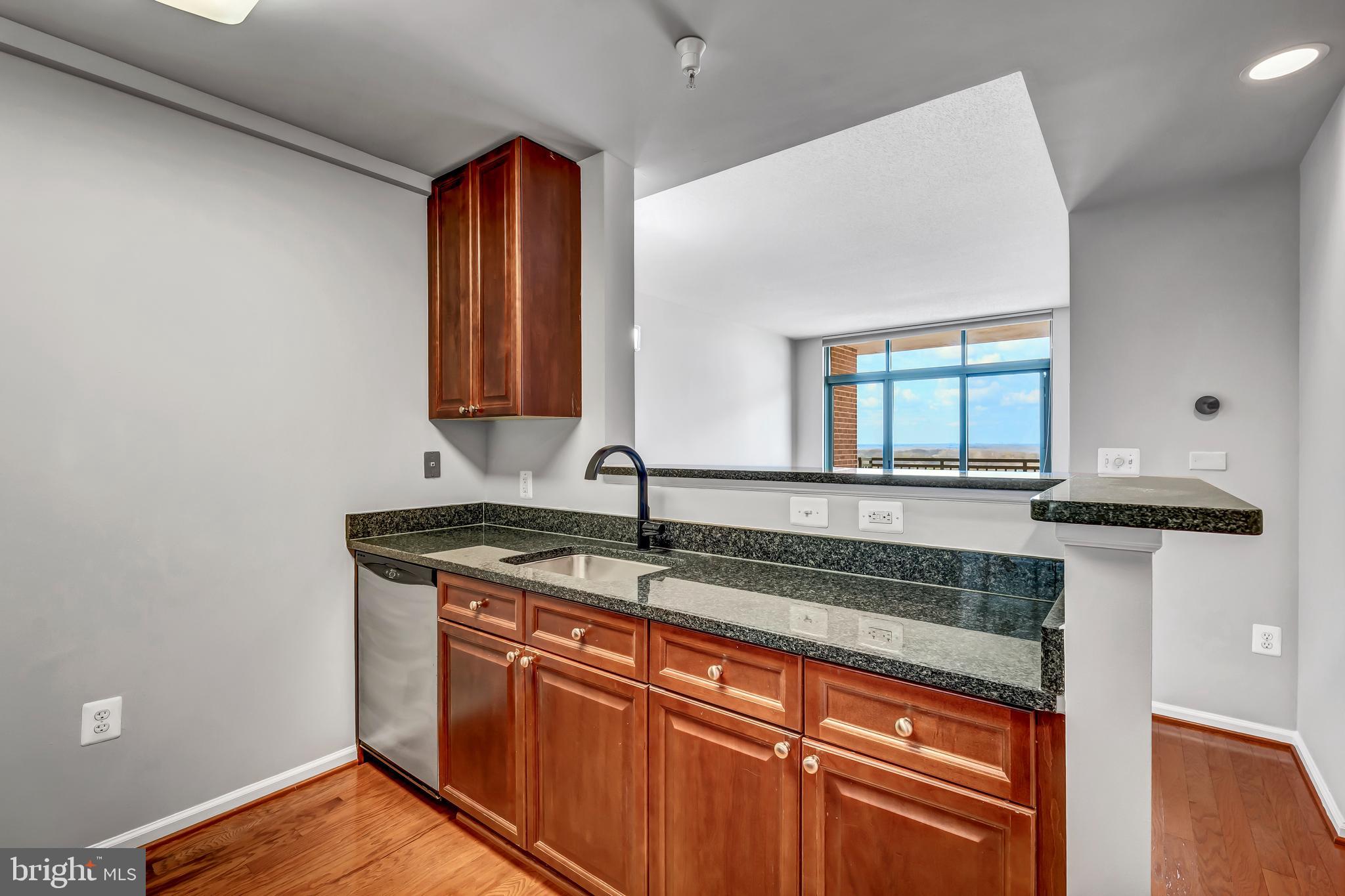 11700 Old Georgetown Road, Unit 1314 North Bethesda, MD 20852 - Photo 14 of 29 a kitchen with stainless steel appliances granite countertop a sink and a wooden cabinets