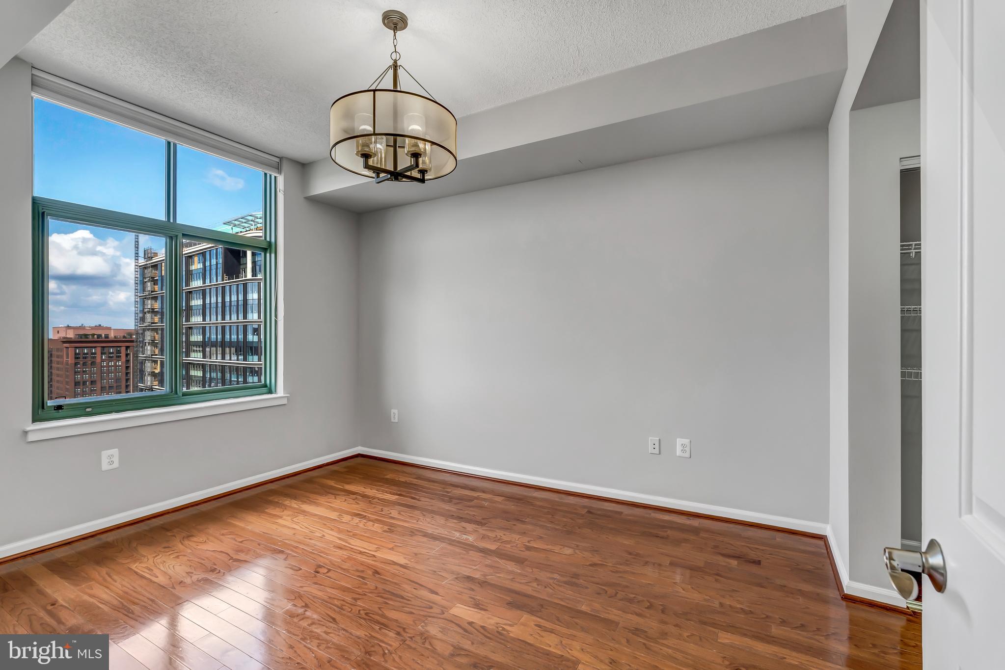 11700 Old Georgetown Road, Unit 1314 North Bethesda, MD 20852 - Photo 21 of 29 a view of an empty room with wooden floor and a window