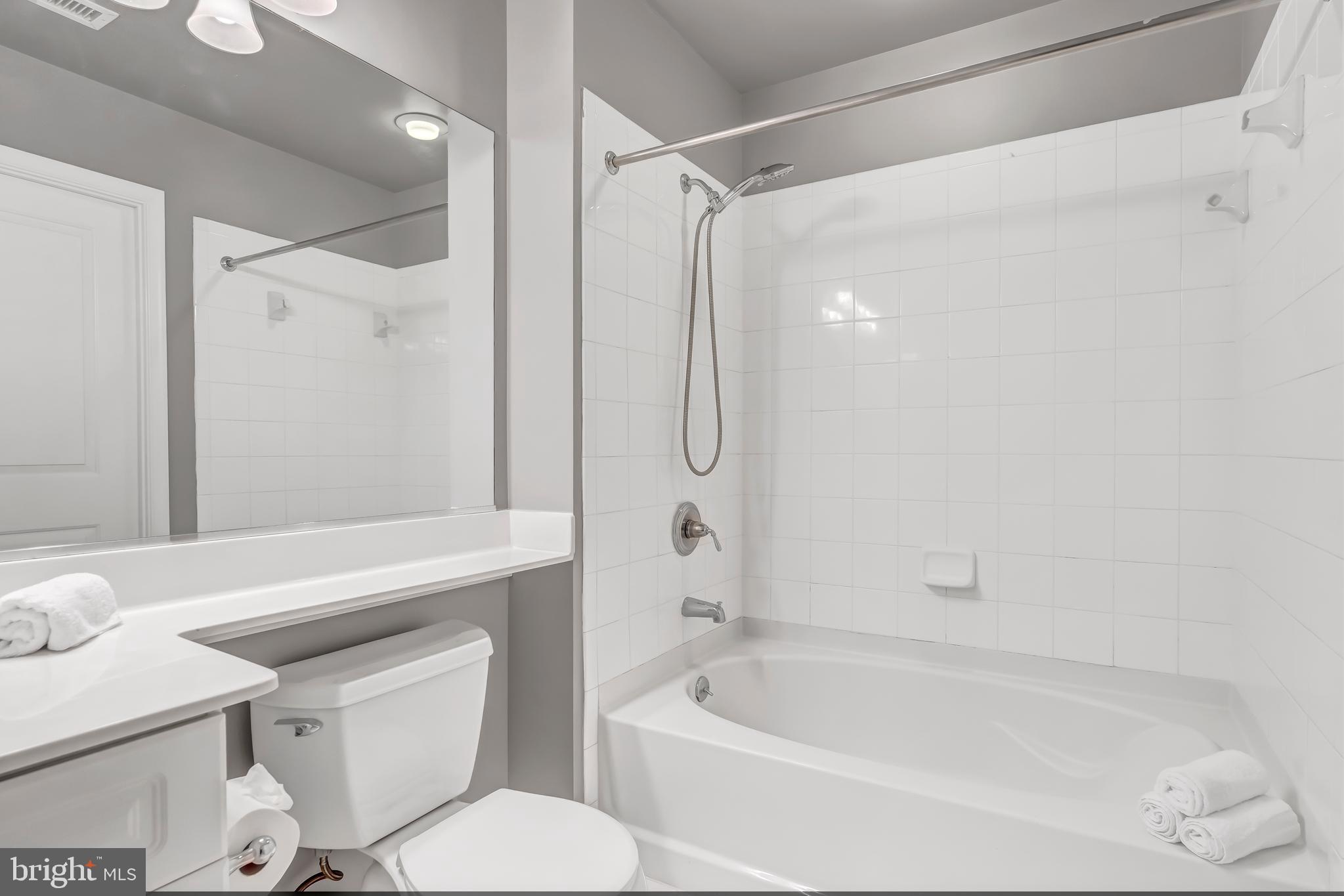11700 Old Georgetown Road, Unit 1314 North Bethesda, MD 20852 - Photo 28 of 29 a bathroom with a granite countertop bathtub shower sink vanity and toilet