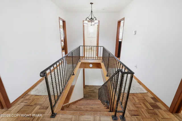 a view of staircase with wooden floor and a chandelier