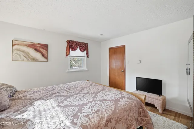 a bedroom with a bed and a flat screen tv
