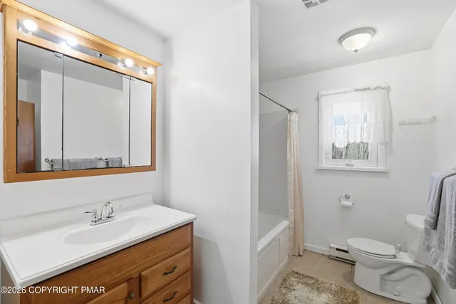 a bathroom with a granite countertop sink mirror vanity and toilet