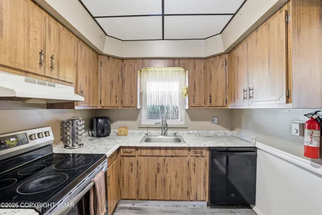 a kitchen with stainless steel appliances granite countertop a stove a sink and cabinets