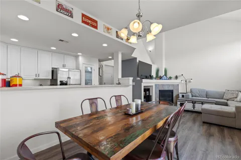 a view of a dining room with furniture a chandelier and wooden floor