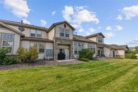 a view of a house with a yard and potted plants