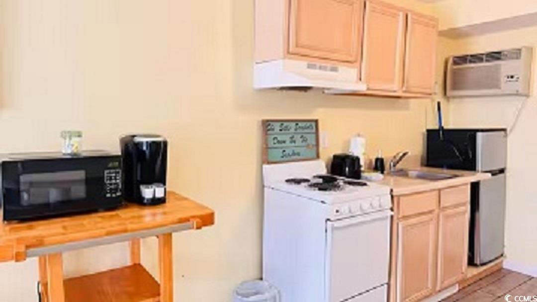 1600 South Ocean Boulevard, Unit 322 Myrtle Beach, SC 29577 - Photo 8 of 16 Kitchen featuring light brown cabinetry, white electric stove, light countertops, black microwave, and stainless steel fridge
