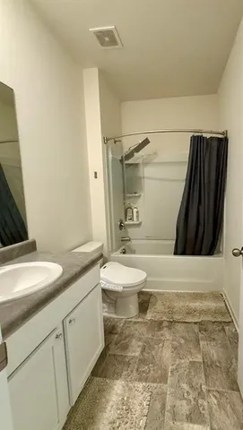 a bathroom with a granite countertop sink toilet and shower