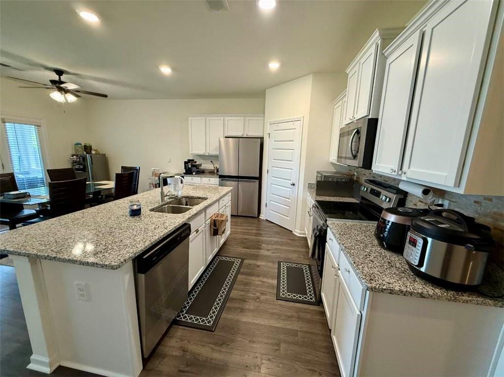 2015 Waycross Lane Dacula, GA 30019 - Photo 15 of 49 a large kitchen with stainless steel appliances granite countertop a sink stove and refrigerator