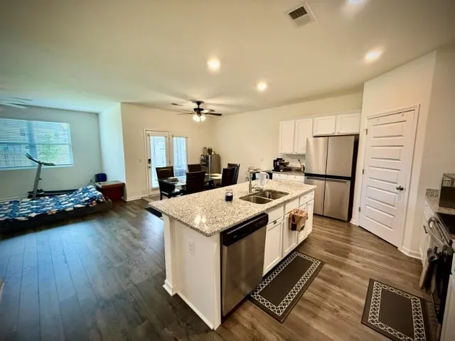 a large white kitchen with sink stove and refrigerator
