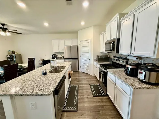 a kitchen with stainless steel appliances granite countertop a sink stove and refrigerator