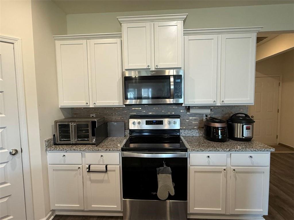 2015 Waycross Lane Dacula, GA 30019 - Photo 19 of 49 a kitchen with granite countertop white cabinets and stainless steel appliances
