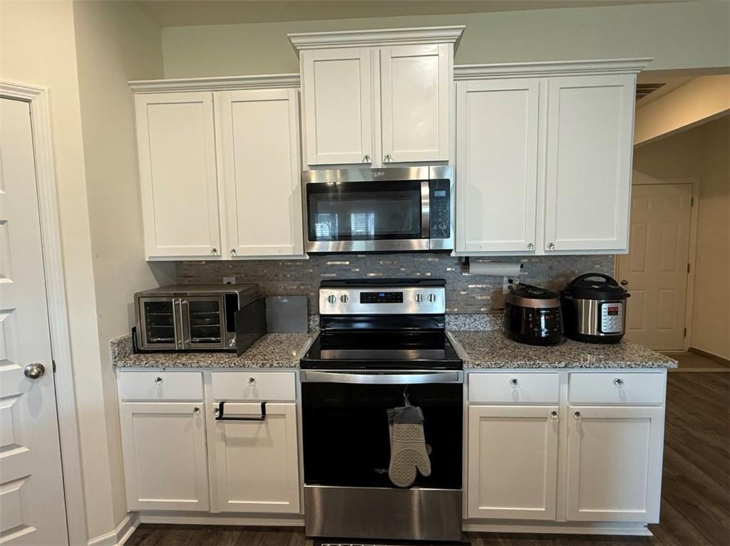 2015 Waycross Lane Dacula, GA 30019 - Photo 20 of 49 a kitchen with granite countertop white cabinets and stainless steel appliances