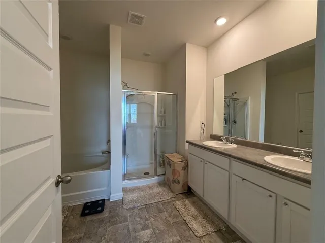 a bathroom with a double vanity sink toilet and shower