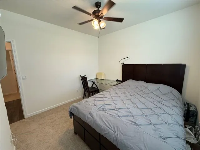 a bedroom with a bed and a ceiling fan