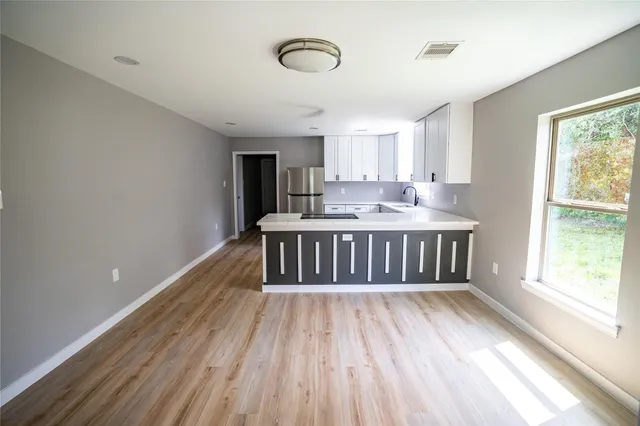 a view of a room with wooden floor and windows