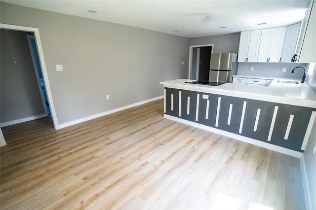 a kitchen with wooden floor and cabinets