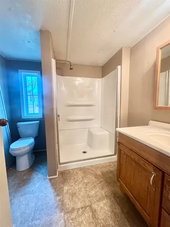 a bathroom with a granite countertop sink toilet and shower