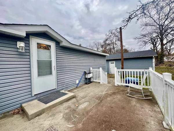 a view of a house with a patio and wooden fence
