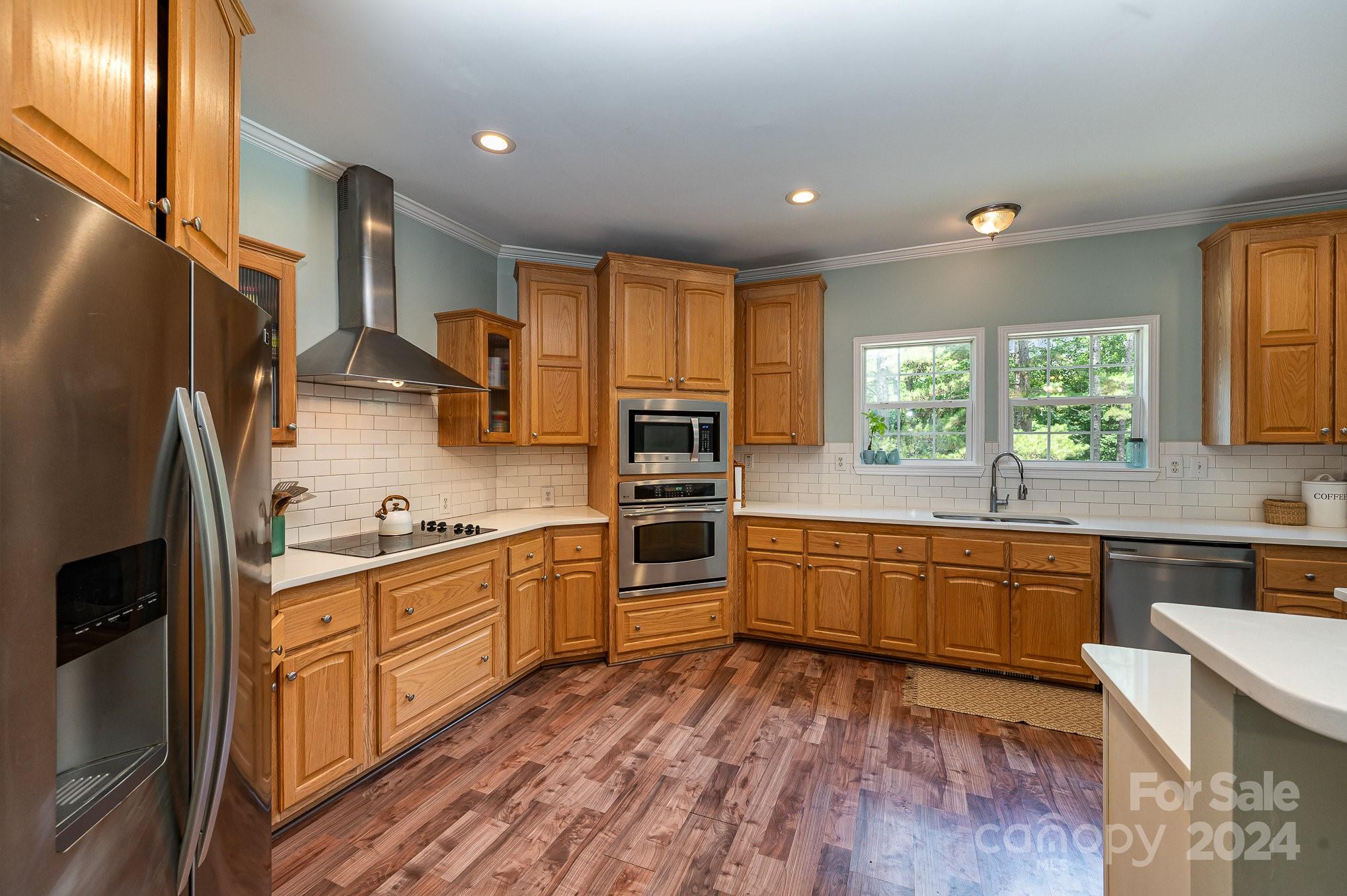 1403 Trinity Church Road Monroe, NC 28112 - Photo 11 of 28 a kitchen with stainless steel appliances granite countertop a refrigerator a sink dishwasher a stove and white countertops with wooden floor