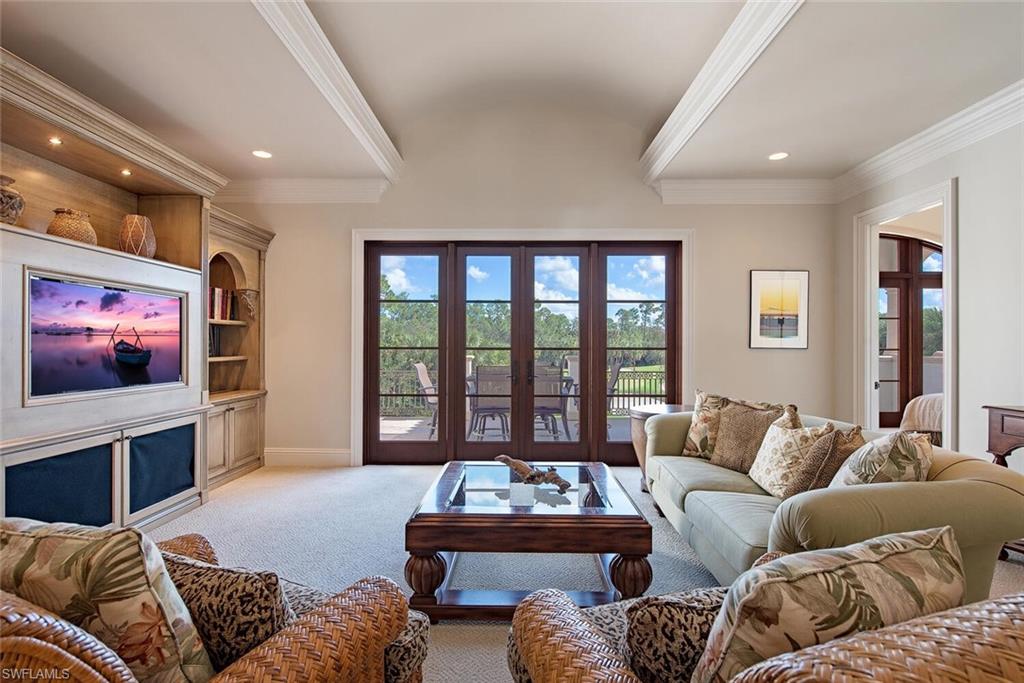 17016 Treviso Way Naples, FL 34110 - Photo 16 of 35 a living room with furniture a large window and a flat screen tv
