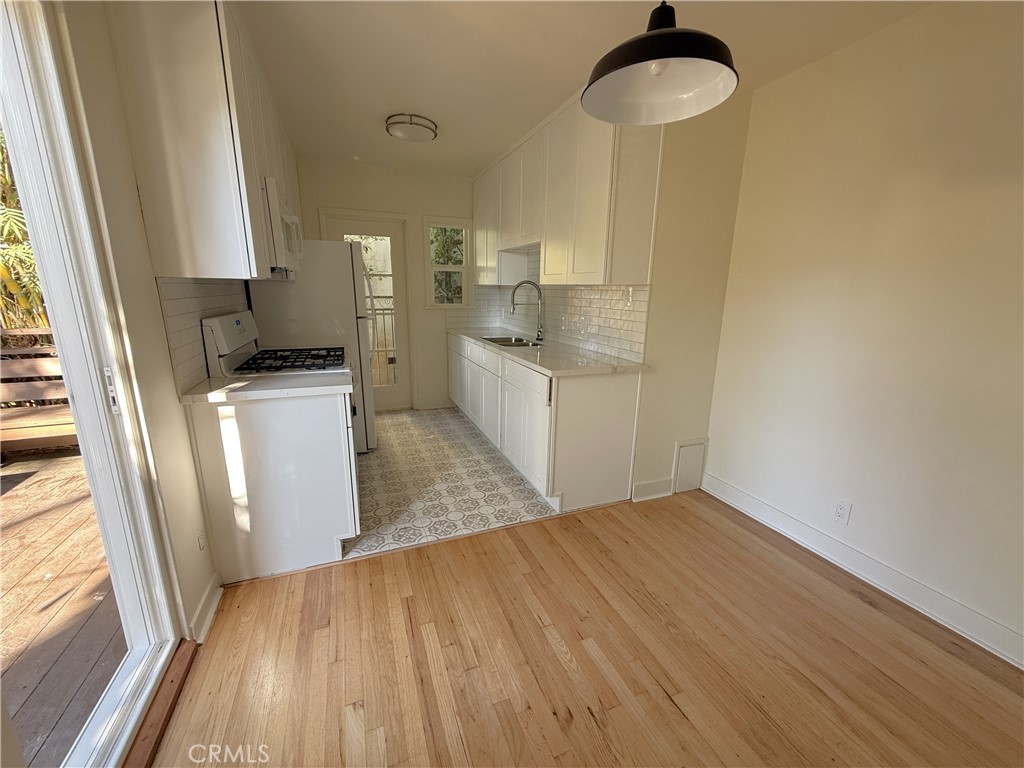 1007 9th Street, Unit 1 Santa Monica, CA 90403 - Photo 6 of 17 a kitchen with granite countertop a sink a counter space and cabinets