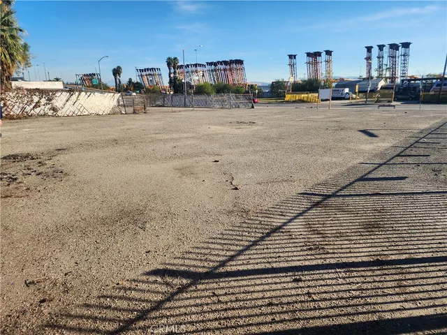 a view of a dry yard with wooden fence
