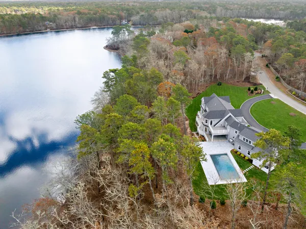 an aerial view of a house with a garden and lake view