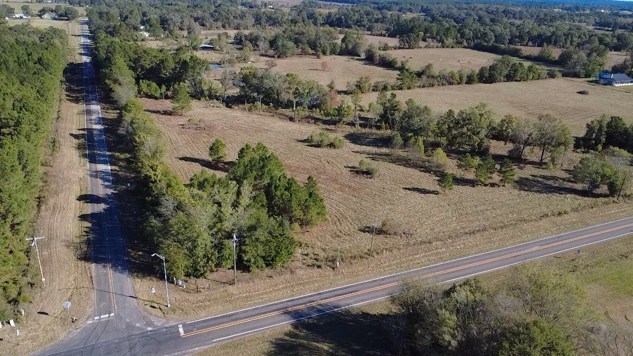 an aerial view of a yard with mountain and trees