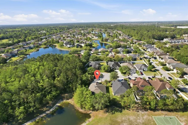 an aerial view of residential houses with outdoor space and trees