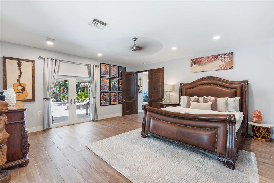 2311 Northeast 47th Street Lighthouse Point, FL 33064 - Photo 26 of 40 a spacious bedroom with a large bed and a wooden floor