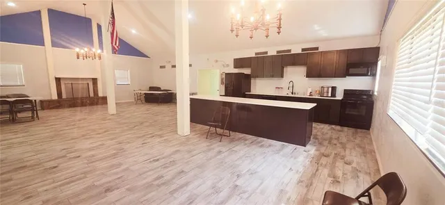 a large kitchen with stainless steel appliances kitchen island granite countertop a sink and cabinets