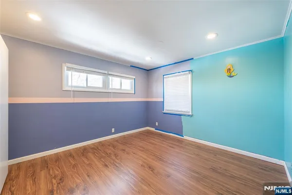 a view of empty room with window and wooden floor