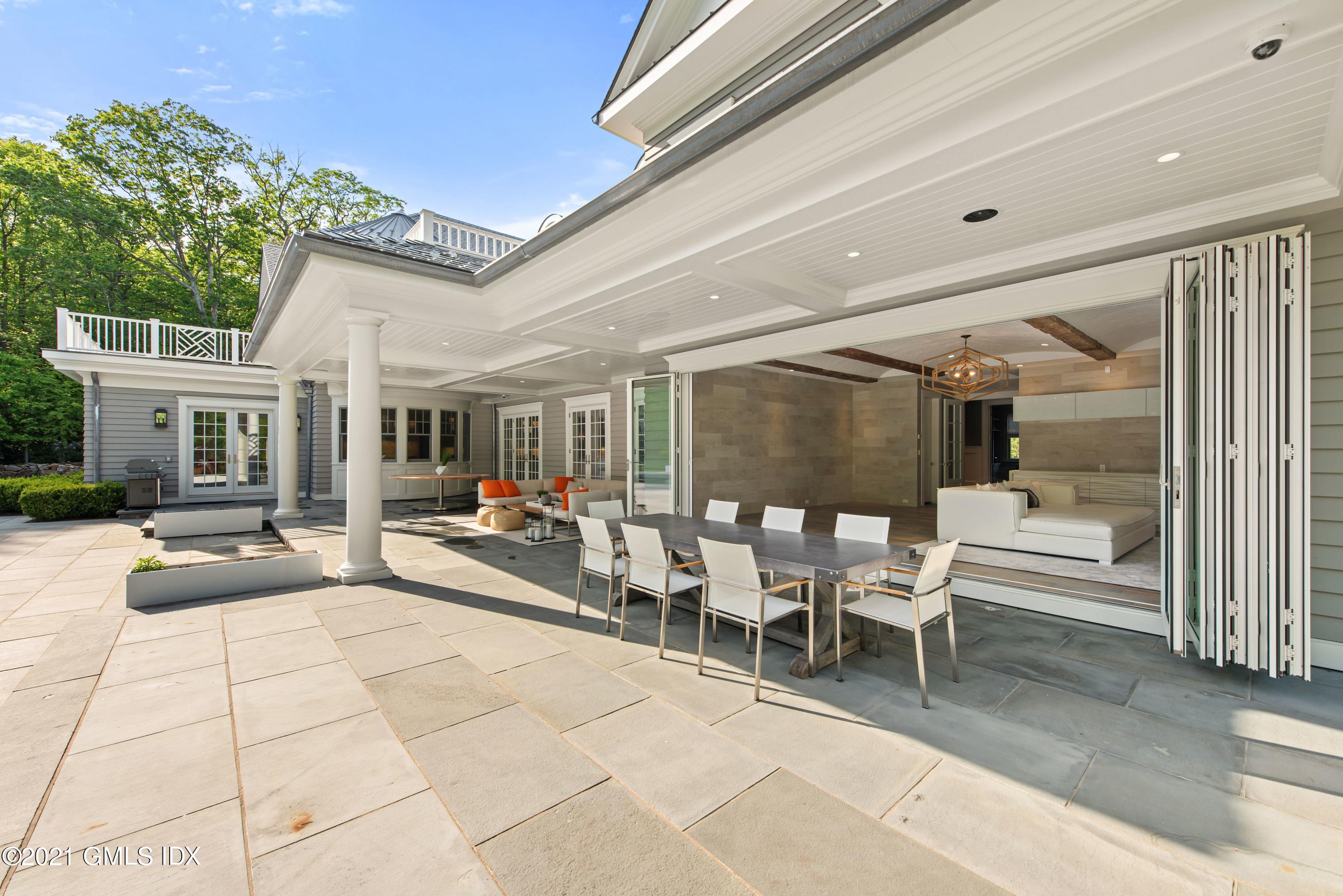 434 Riversville Road Greenwich, CT 06831 - Photo 36 of 47 a view of a patio with table and chairs potted plants with floor to ceiling window