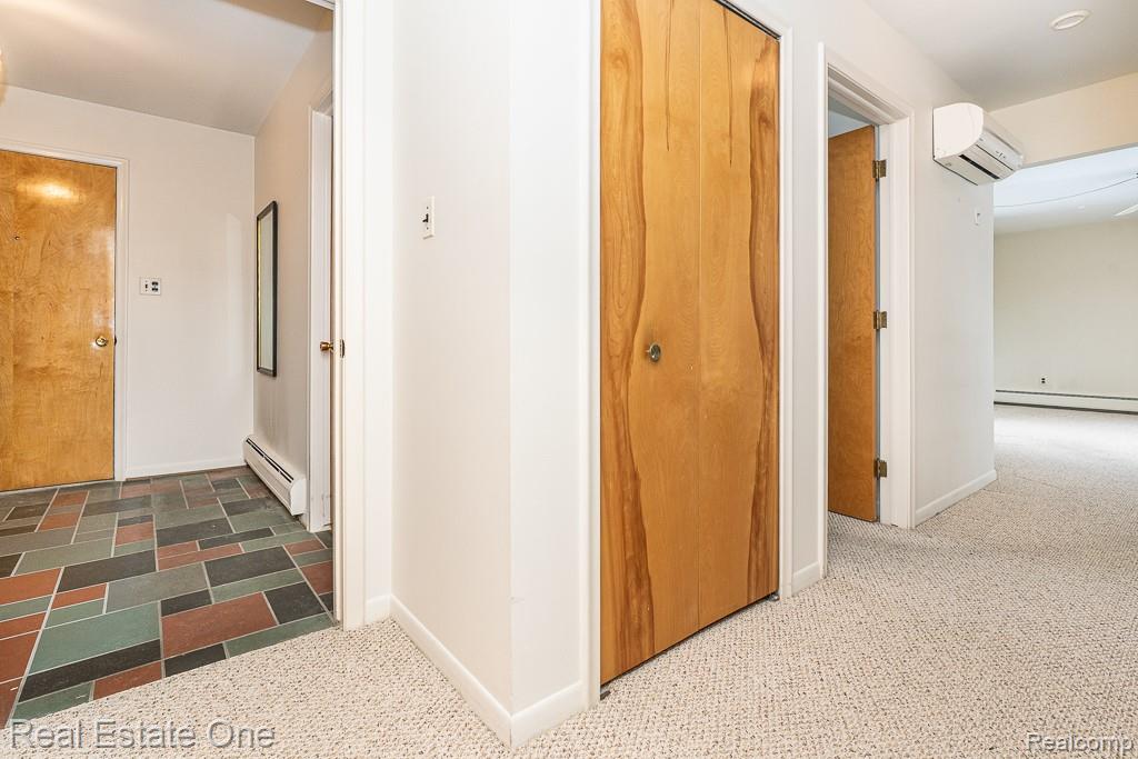 28777 West 11 Mile Road Farmington, MI 48336 - Photo 4 of 53 Hallway featuring carpet flooring, a baseboard radiator, and an AC wall unit, leading to the Living room for unit one