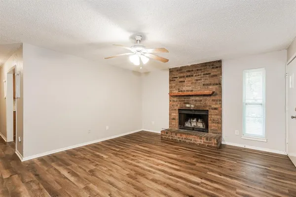 a view of a livingroom with a fireplace a ceiling fan and a fireplace