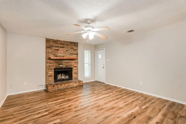 wooden floor fireplace and windows in an empty room