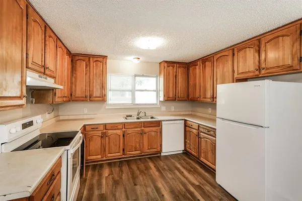 a kitchen with stainless steel appliances granite countertop a sink stove refrigerator and cabinets