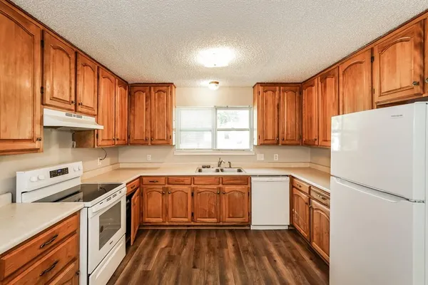 a kitchen with a sink cabinets stainless steel appliances and a window