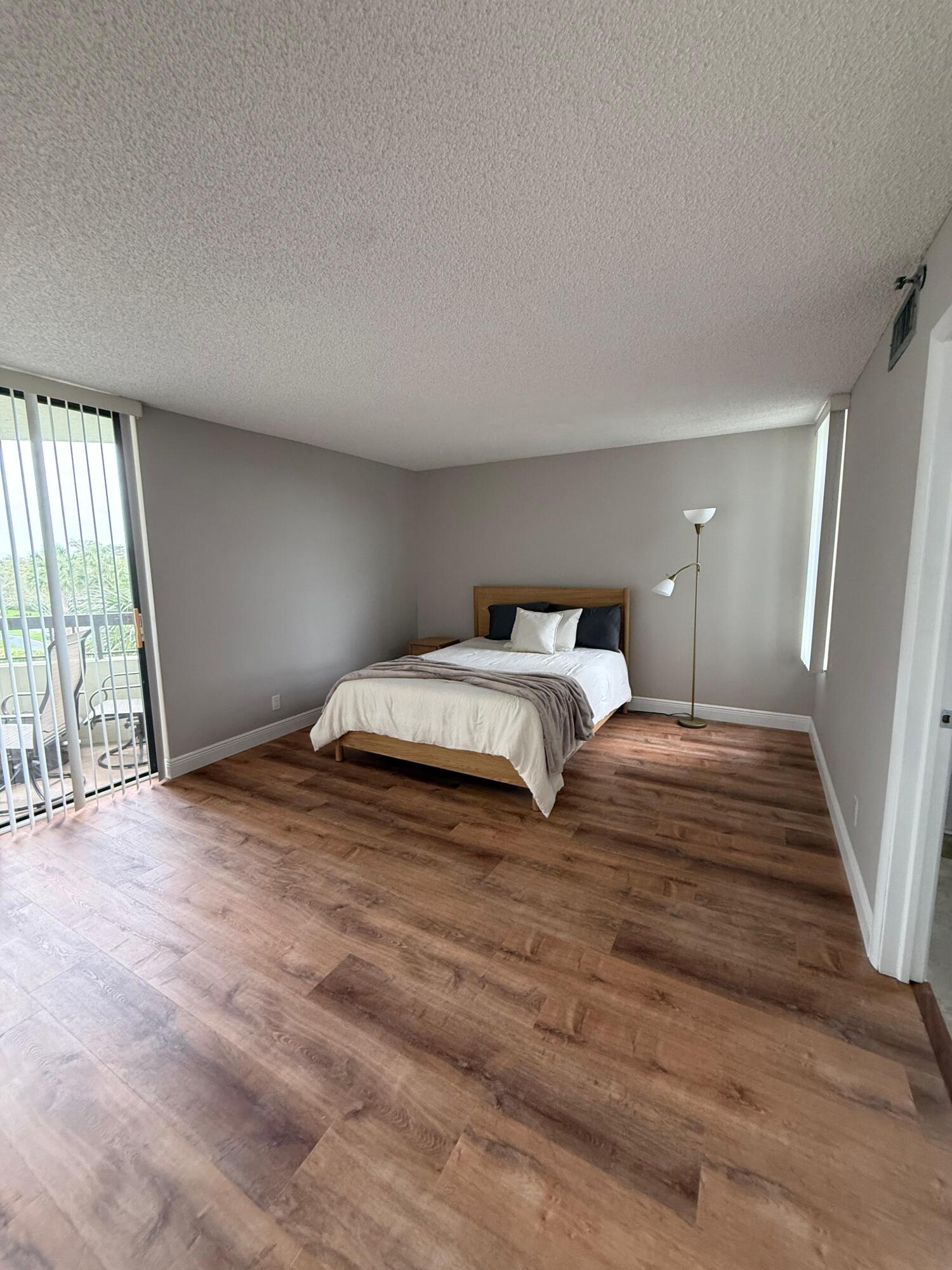 6372 La Costa Drive, Unit 306 Boca Raton, FL 33433 - Photo 11 of 23 a bedroom with a bed and a large window